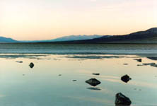 rocks in water with sun reflecting