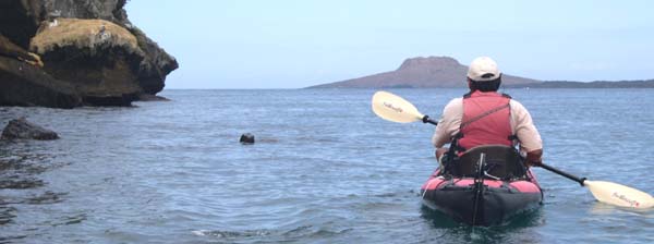 Jorge kayaking with a sea lion and Sombrero Chino on the right