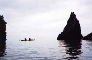 Two paddlers along the rocks