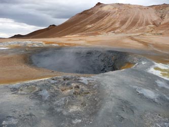 A hole of mud and ashen peaks looks like the land where dinosaurs still roam