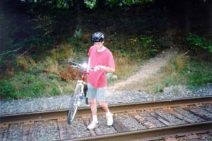 Bill carrying bike across tracks