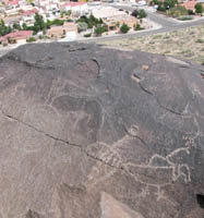 petroglyphs with city in the background